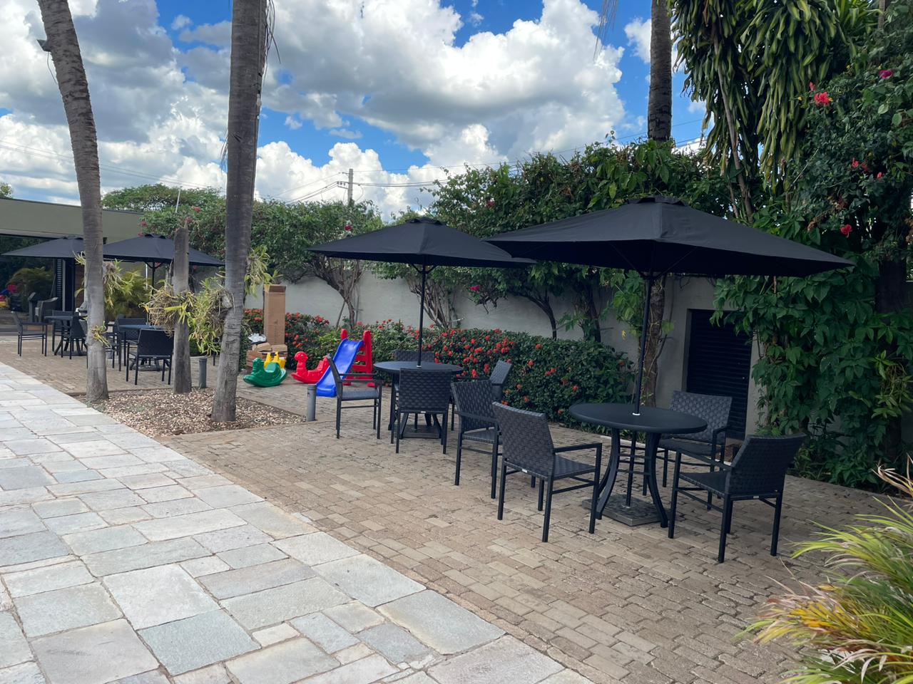 Ombrelone Centerflex Umbrosa — com pilar central sobre mesa em área externa — foto 5